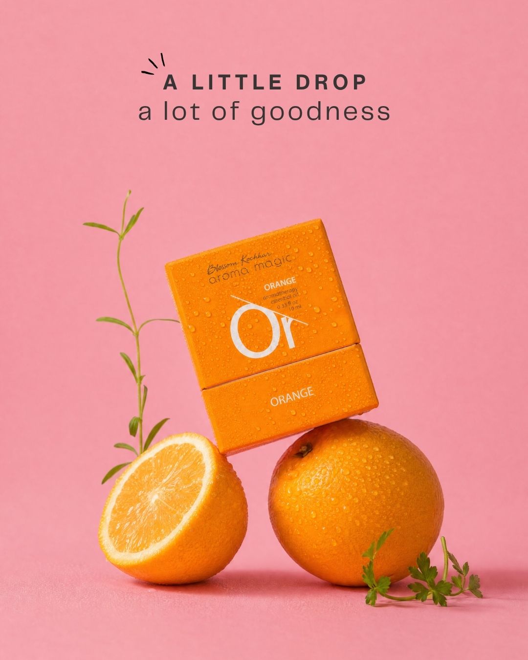 Orange essential oil box balanced on fresh oranges