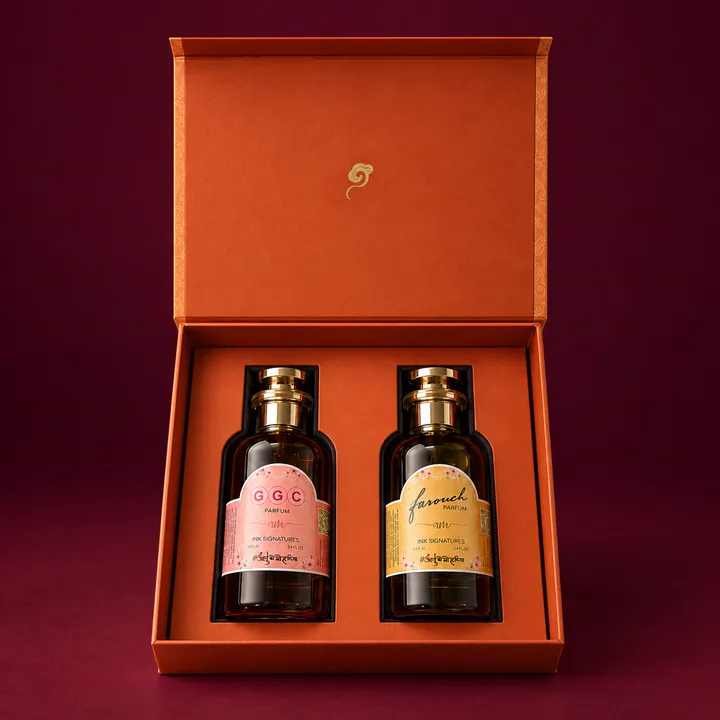 An open orange box holding two bottles whose labels carry the same initials