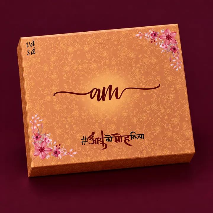 An orange VASA box with initials in script, a hashtag in Hindi and painted flowers in two corners