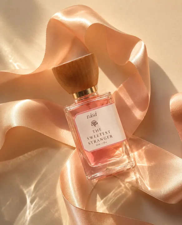 Sweetest Stranger lying in a loop of peach satin ribbon