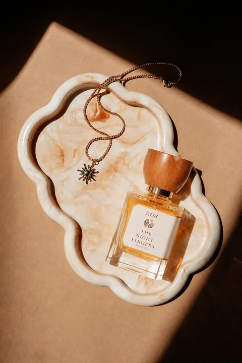 The Night Lingers in a cream marbled tray with a gold star necklace